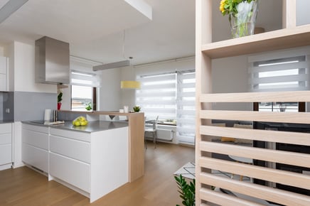 Moderní světlý interiér kuchyně s obývacím pokojem a dřevěnou podlahou